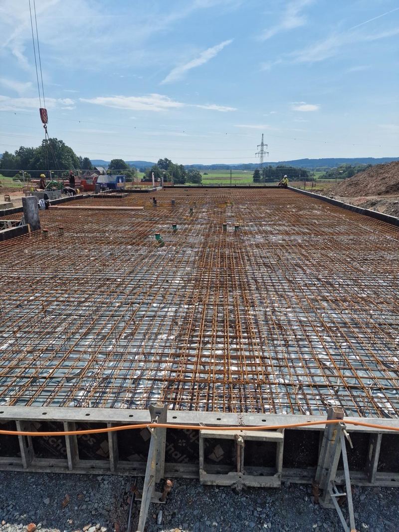 Bewehrte Bodenplatte mit Randschalung, im Hintergrund Landschaft
